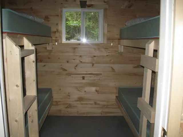 Cette chambre rustique est équipée de deux lits superposés en bois.