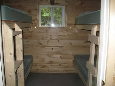 Cette chambre rustique est équipée de deux lits superposés en bois.