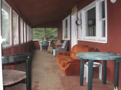 Une véranda fermée et meublée du chalet Outpost pour se détendre.