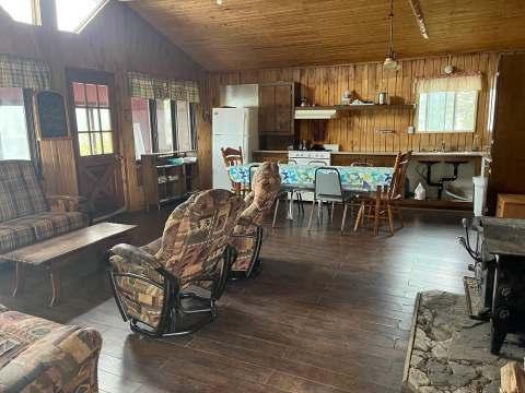 L'aire ouverte du chalet comprend un coin salon avec foyer et une cuisine équipée pour les repas.