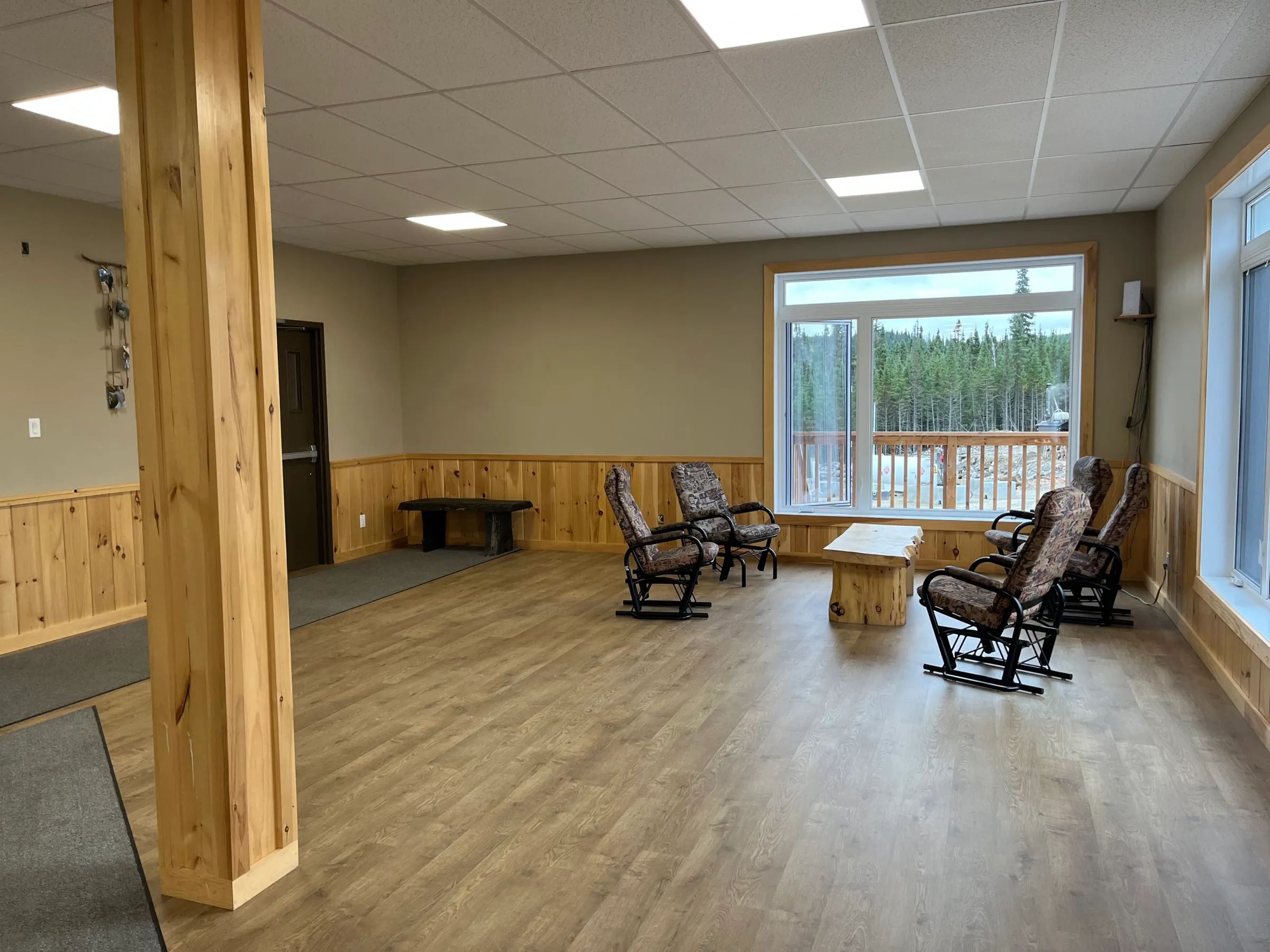 Espace de détente aménagé avec des chaises berçantes dans la salle commune de l'auberge.