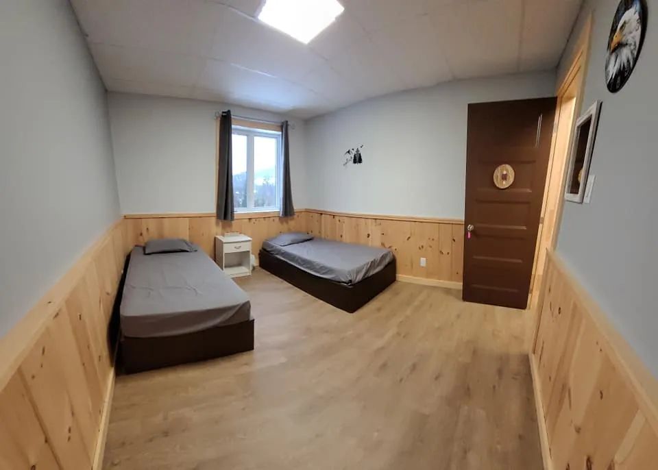 Cette chambre de l'auberge comprend deux lits simples et un lambris de bois au bas des murs.