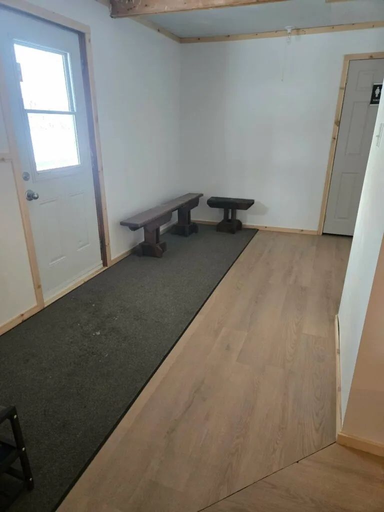 L'entrée de La Petite Auberge offre un espace pratique avec des bancs pour se déchausser.