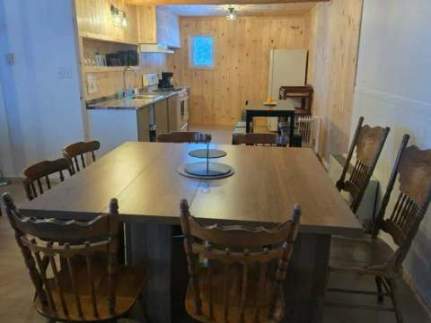 La cuisine ouverte et la salle à manger de La Petite Auberge sont aménagées avec des boiseries.