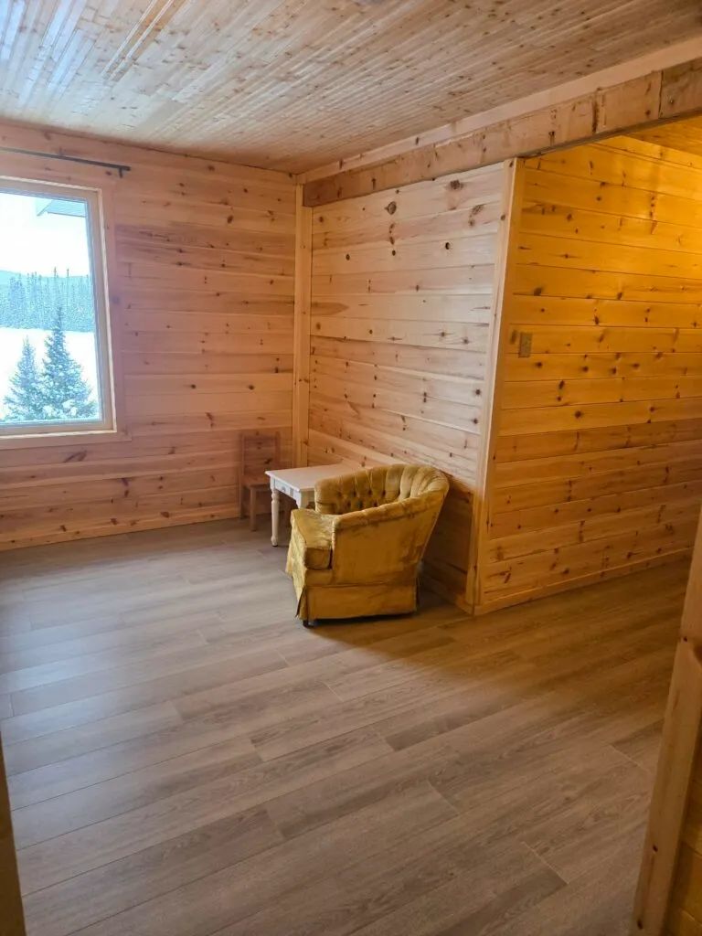 Coin lecture aménagé dans une chambre de la Petite Auberge avec vue sur la forêt.