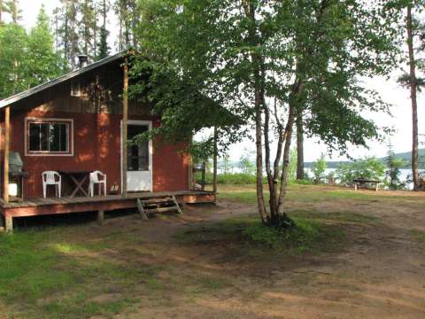 Chalet 6 features an outdoor porch with table and chairs facing the lake.