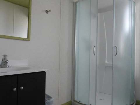 La salle de bain fonctionnelle des maisons mobiles comprend une douche et un lavabo.