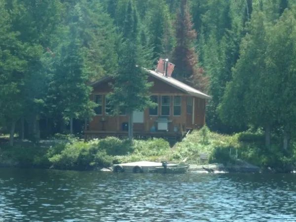The Bapati cabin is located by the water, surrounded by trees.