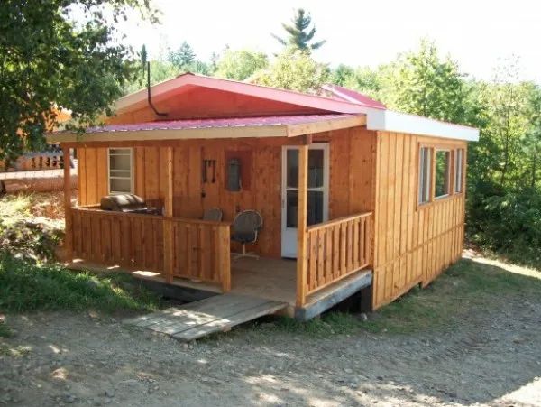 Vue du Camp 1 avec sa galerie couverte et son entrée située en forêt.