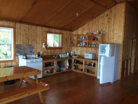 La cuisine équipée du chalet Bapati dispose d'une cuisinière, d'un réfrigérateur et d'une table à manger.