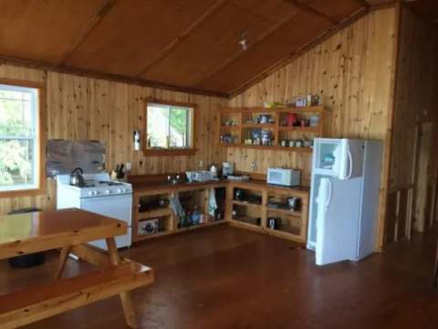 Vue de la cuisine fonctionnelle et de l'espace repas dans le chalet Bapati.