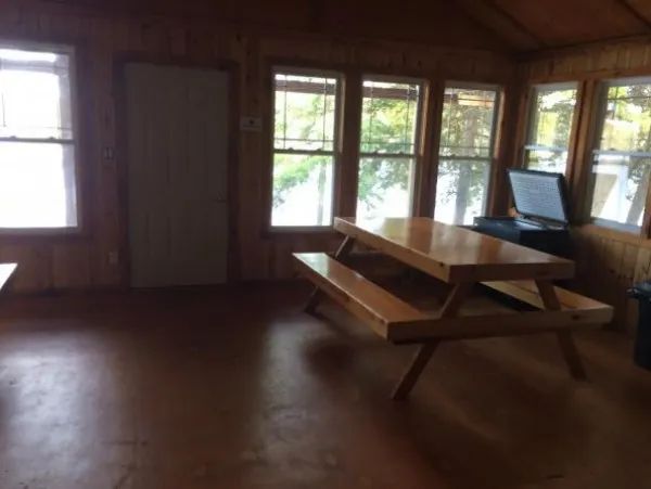 La salle à manger du chalet Bapati dispose d'une grande table en bois et de nombreuses fenêtres.