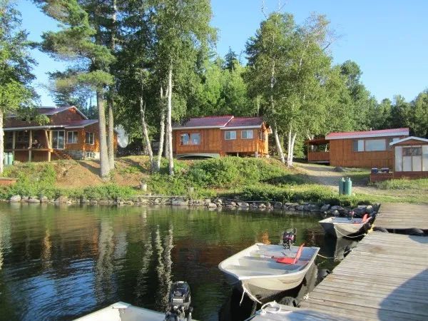 Vue des chalets de la pourvoirie depuis le quai au bord de l'eau.