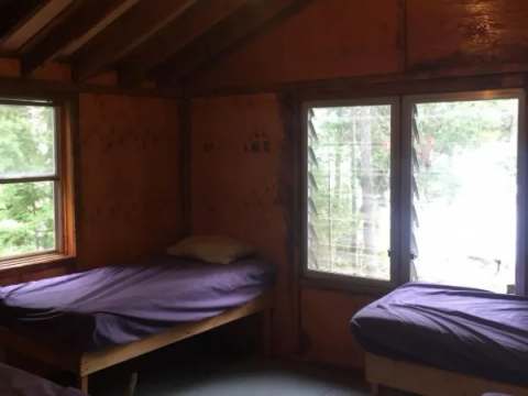 Cette chambre rustique est équipée de deux lits simples avec vue sur la forêt.