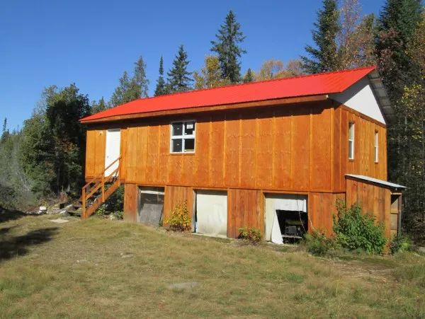 Vue extérieure du chalet Trap Lake avec son toit rouge et son revêtement en bois.