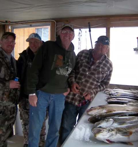Pêcheur présentant sa prise de truite de lac chez Territoire de l'Orignal, Outaouais, Québec