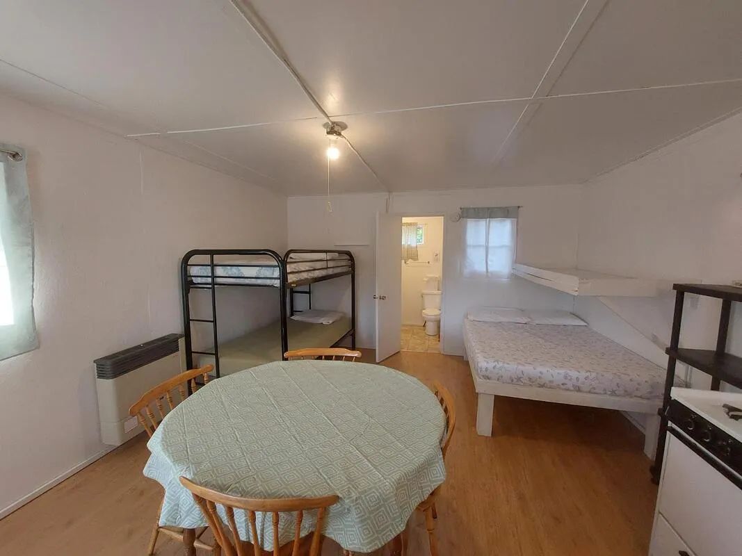 Interior view of camp 6 featuring beds, a dining table, and access to a private bathroom.