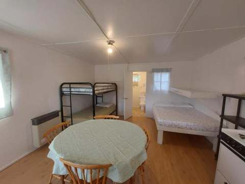 Interior view of camp 6 featuring beds, a dining table, and access to a private bathroom.