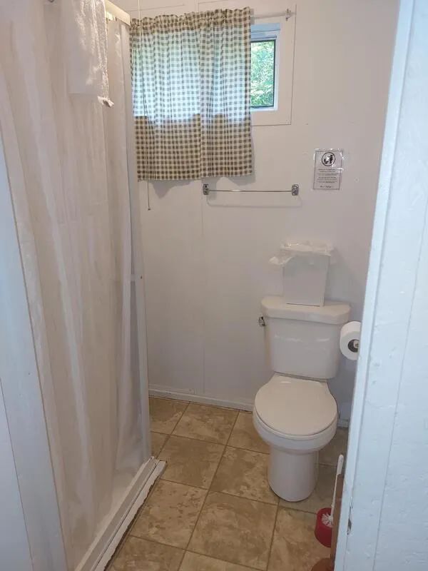 View of the functional bathroom with shower and toilet in Camp 6.