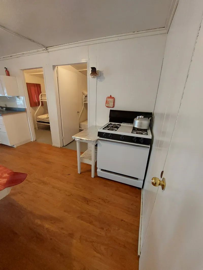 Vue de la cuisine équipée et de l'accès aux chambres du chalet.