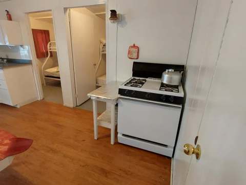Vue de la cuisine équipée et de l'accès aux chambres du chalet.