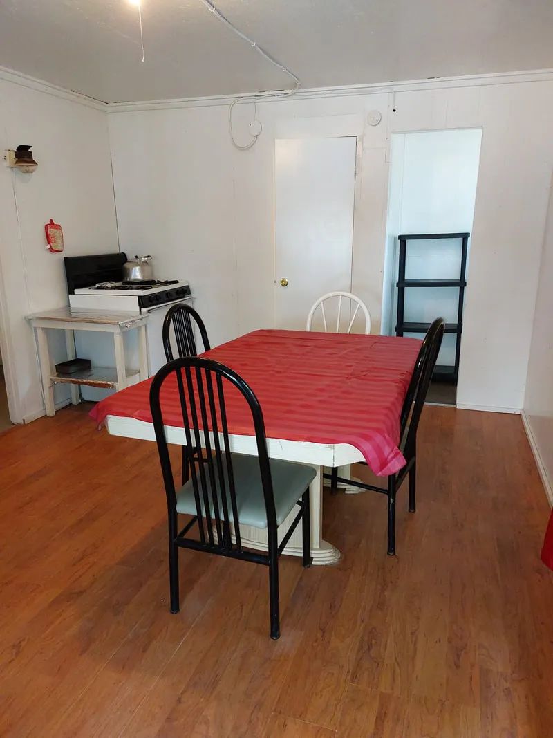 La salle à manger du chalet comprend une table avec chaises et une cuisinière adjacente.