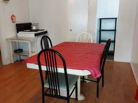 La salle à manger du chalet comprend une table avec chaises et une cuisinière adjacente.