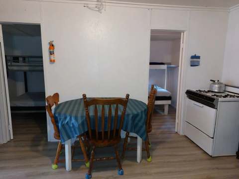 View of the open area including the dining table and stove, with access to the bedrooms.