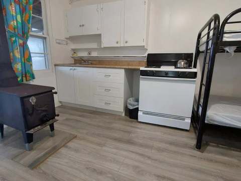 La cuisinette du chalet comprend un poêle, des espaces de rangement et un poêle à bois.