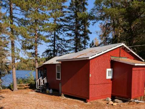 Le chalet 1 est situé en bordure de lac, entouré d'arbres.