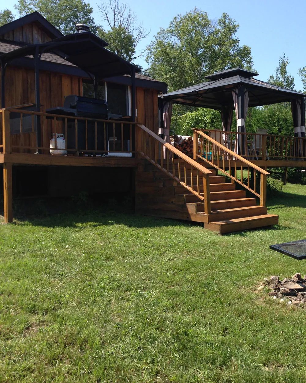 Le chalet dispose d'une grande terrasse en bois équipée d'un barbecue et d'un gazebo extérieur.