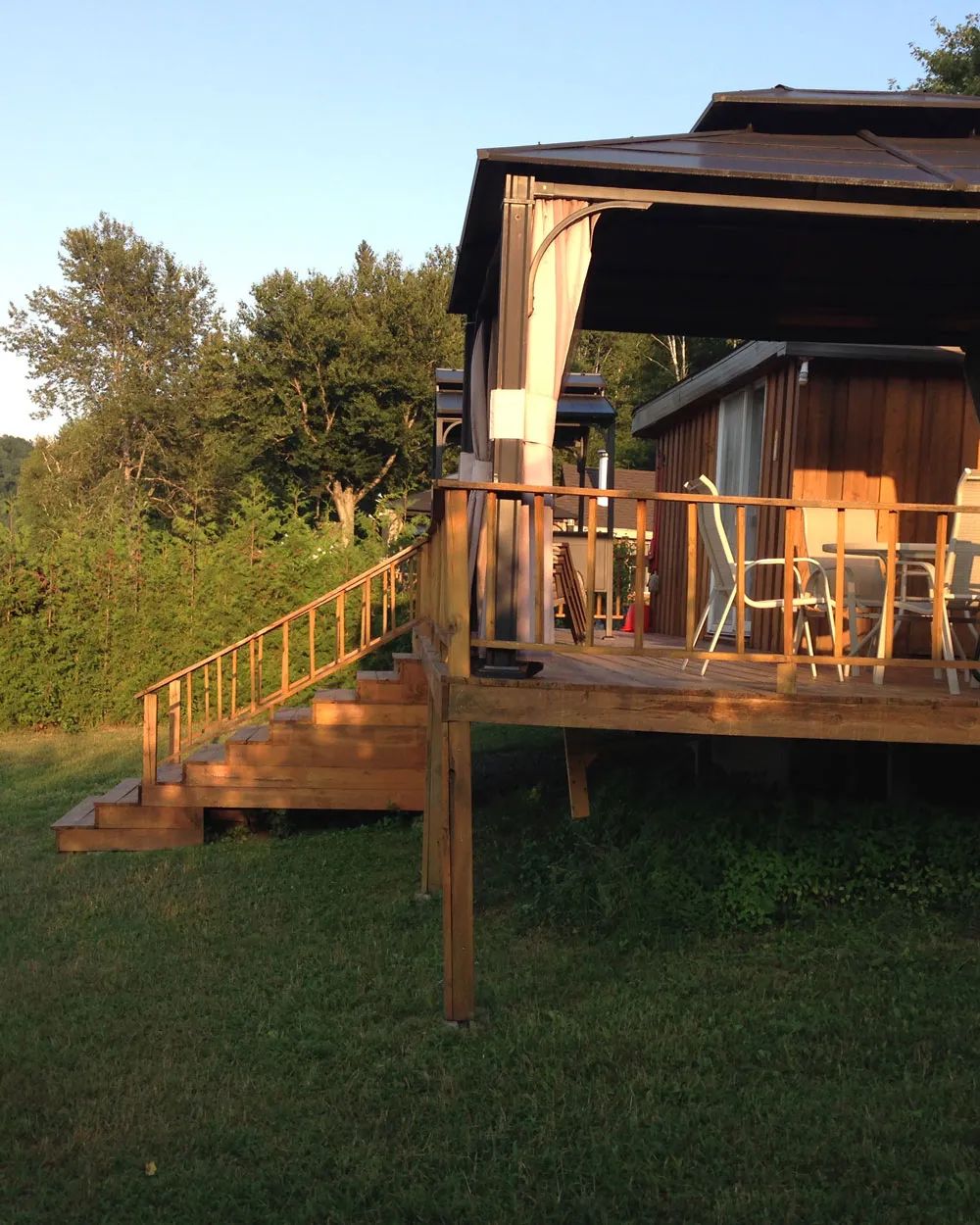 Une terrasse en bois avec gazebo est aménagée devant le Chalet Coquet.