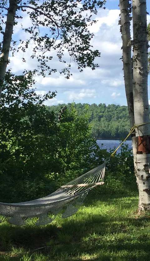 Relaxation en hammock au bord de l'eau chez Domaine de la Baie au Sable, Laurentides, Québec