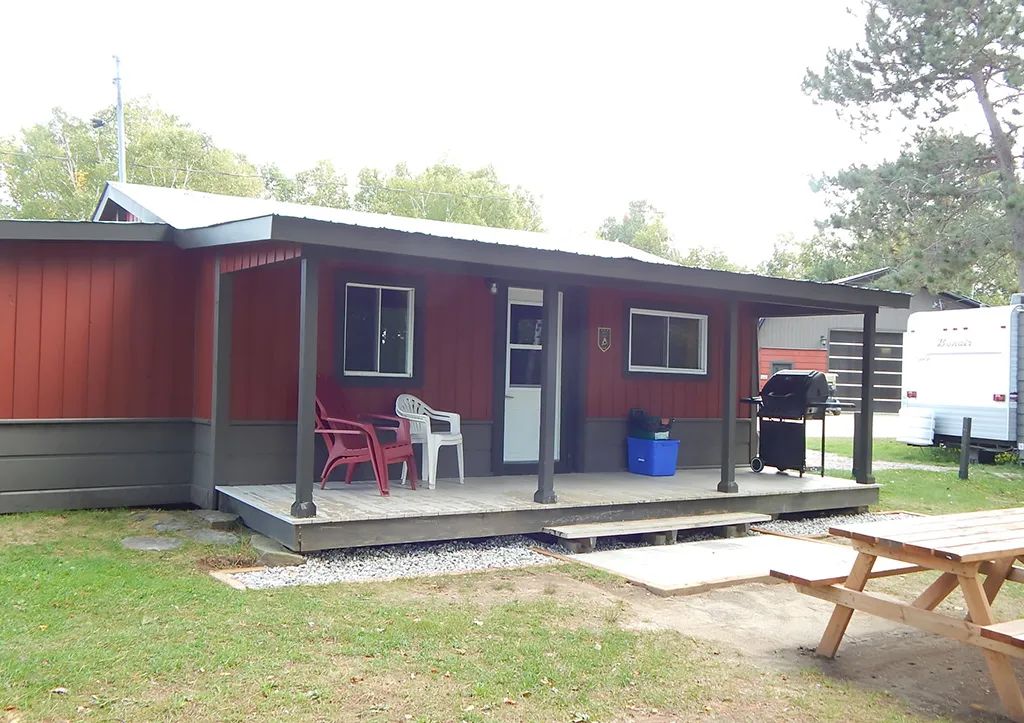 Le chalet 1 dispose d'une galerie couverte, de chaises extérieures et d'un barbecue pour vos repas.