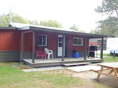 Le chalet 1 dispose d'une galerie couverte, de chaises extérieures et d'un barbecue pour vos repas.