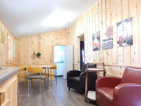 Vue de l'aire de vie principale du chalet 1 avec table à manger et espace de détente.