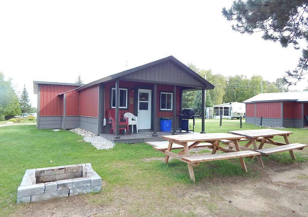 Le chalet 3 dispose d'une galerie couverte, d'une table de pique-nique et d'un espace foyer extérieur.