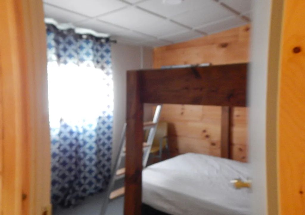 Vue de l'intérieur d'une chambre du chalet 3 avec un lit superposé en bois.