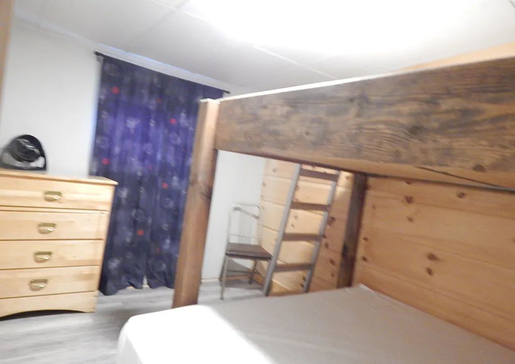 Une chambre du chalet 6 équipée d'un lit superposé et d'une commode.