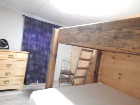 Une chambre du chalet 6 équipée d'un lit superposé et d'une commode.