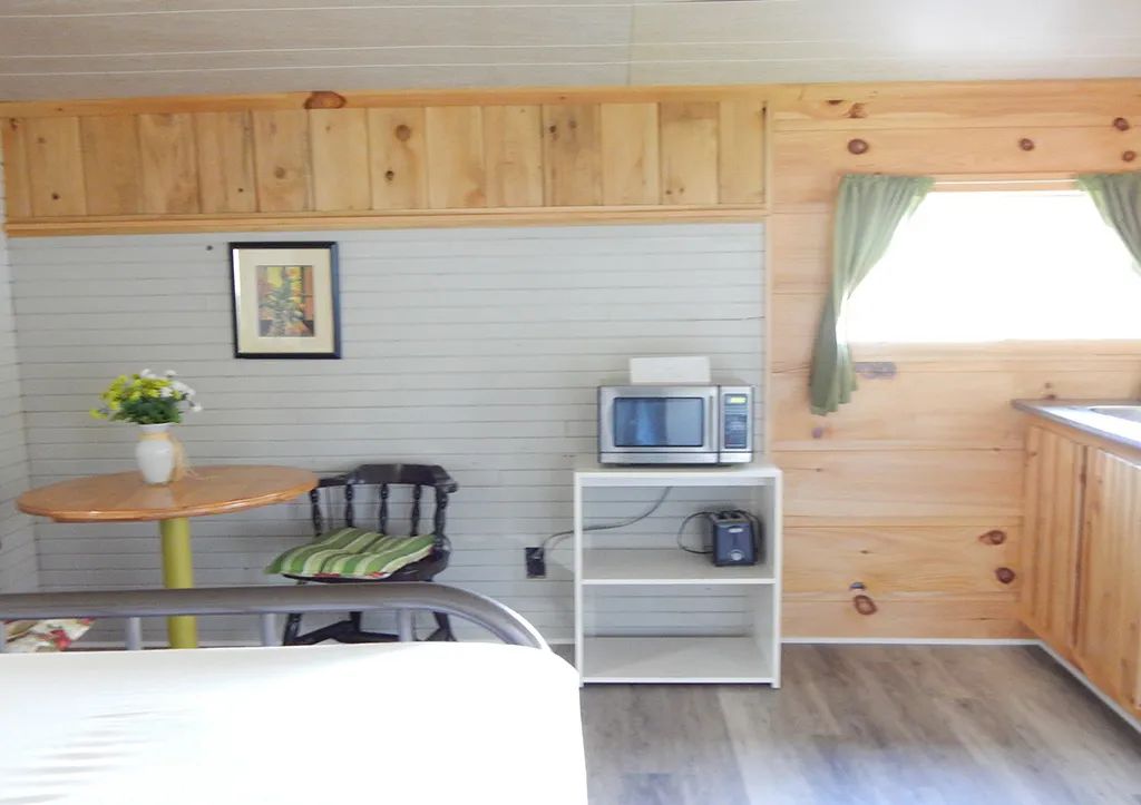 Coin repas et équipement de cuisine dans le chalet 7 du Pavillon Arc-en-ciel.