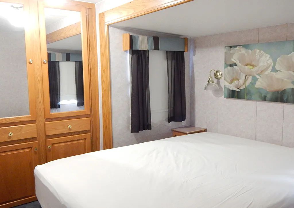 La chambre à coucher de la roulotte est équipée d'un lit double et de rangements en bois intégrés.