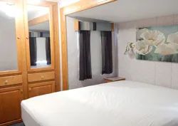 Vue de la chambre à coucher principale incluant un lit et des espaces de rangement intégrés.