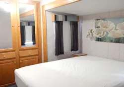 Vue de la chambre à coucher principale incluant un lit et des espaces de rangement intégrés.