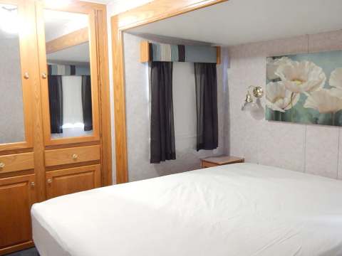 La chambre à coucher de la roulotte est équipée d'un lit double et de rangements en bois intégrés.