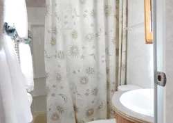 La salle de bain de la roulotte comprend une douche avec rideau et un lavabo.