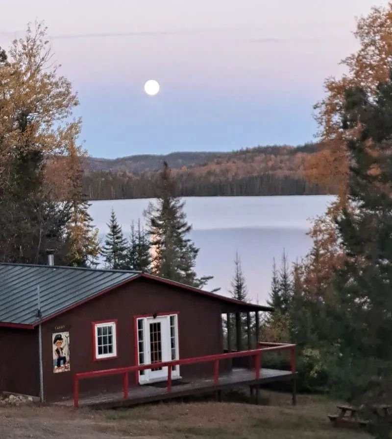 View of Le Canot cottage by the lake under the full moon light.