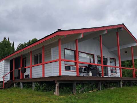 Le chalet Le Familial dispose d'une grande galerie couverte et d'un barbecue extérieur.