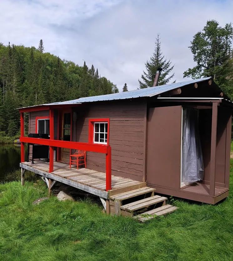 Exterior view of Le Panoramique cabin with its furnished deck by the water.