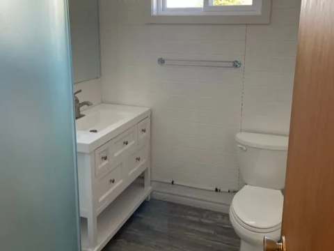 La salle de bain du Lodge 1 dispose d'un lavabo avec rangement et d'une toilette.
